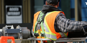 Construction worker in an orange reflective vest.